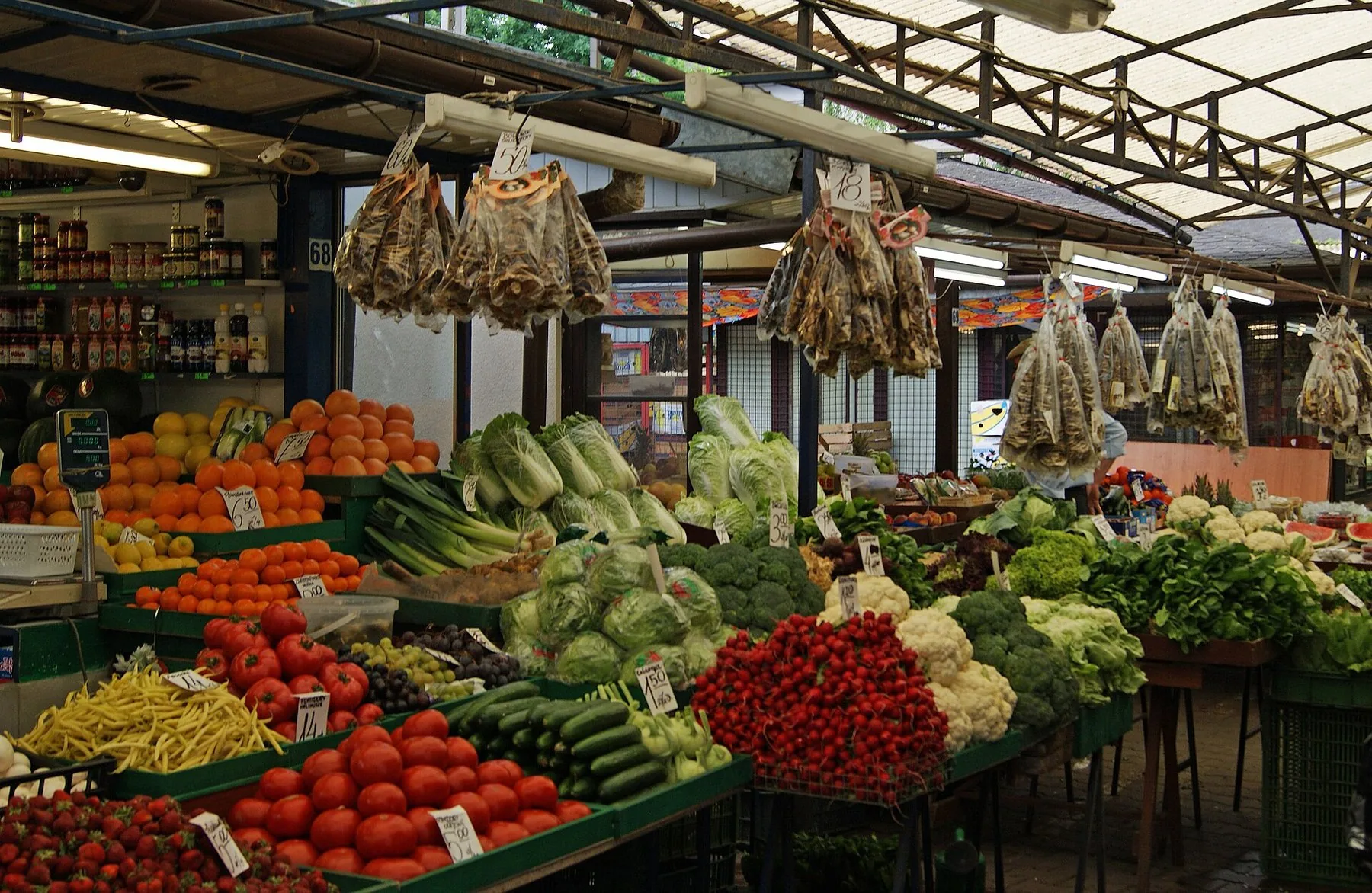 Grøntsager og frugt med prisskilte i en bod på torvet Rynek Kleparski i Kraków