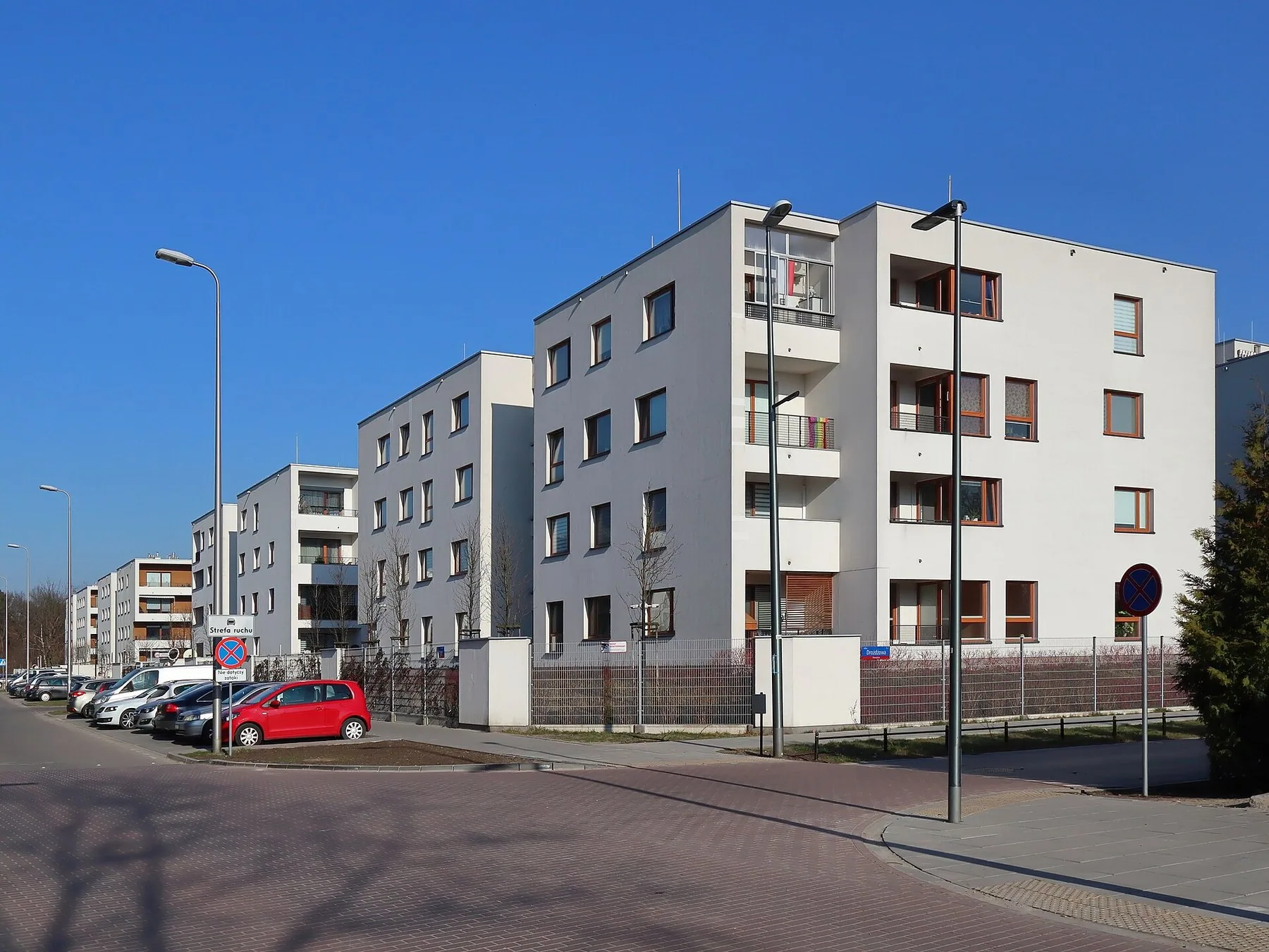 Nye, hvite boligblokker i et boligfelt i Warszawa under blå himmel
