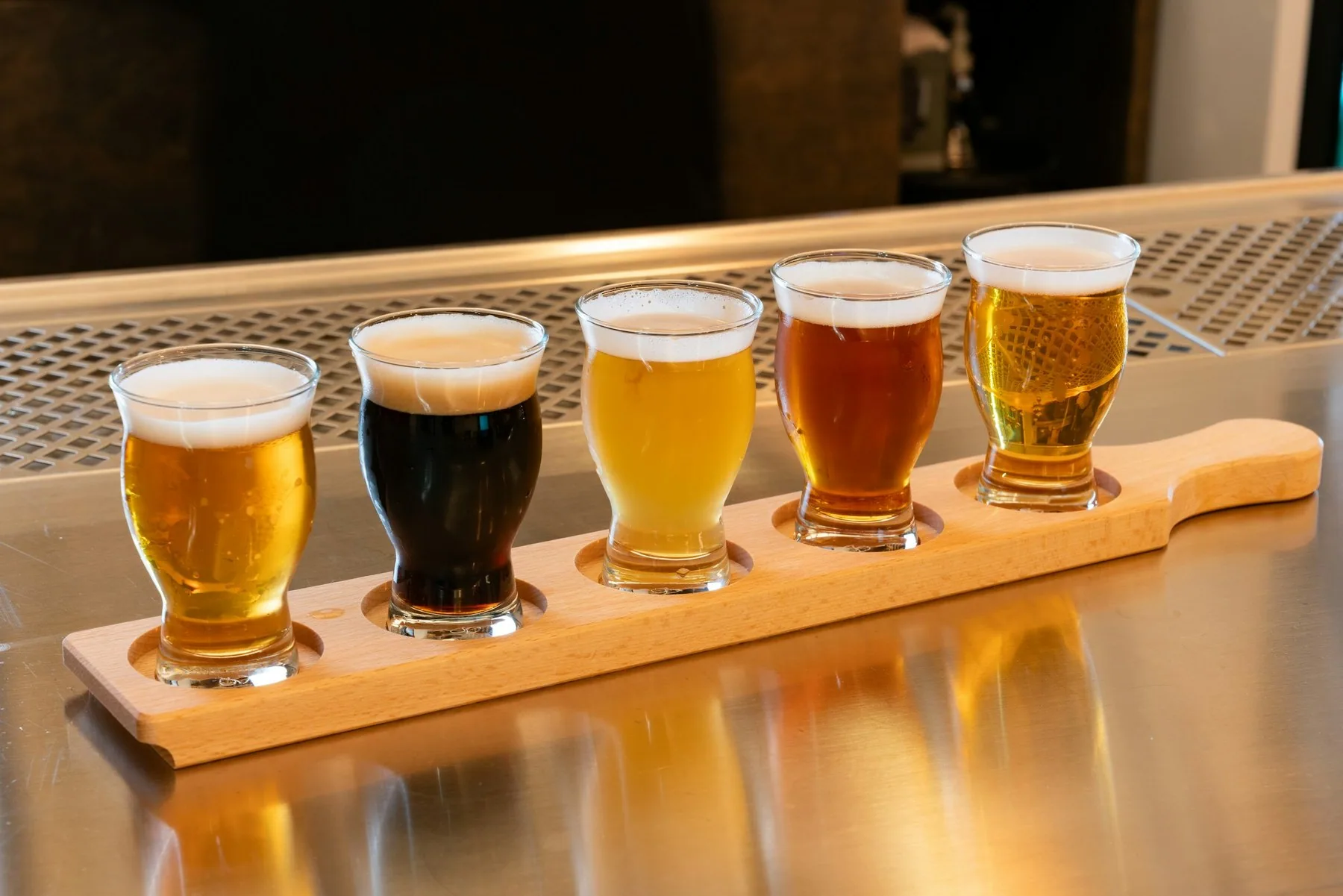 Smakebrett med fem glass øl i ulike farger, fra lys pils til mørk porter