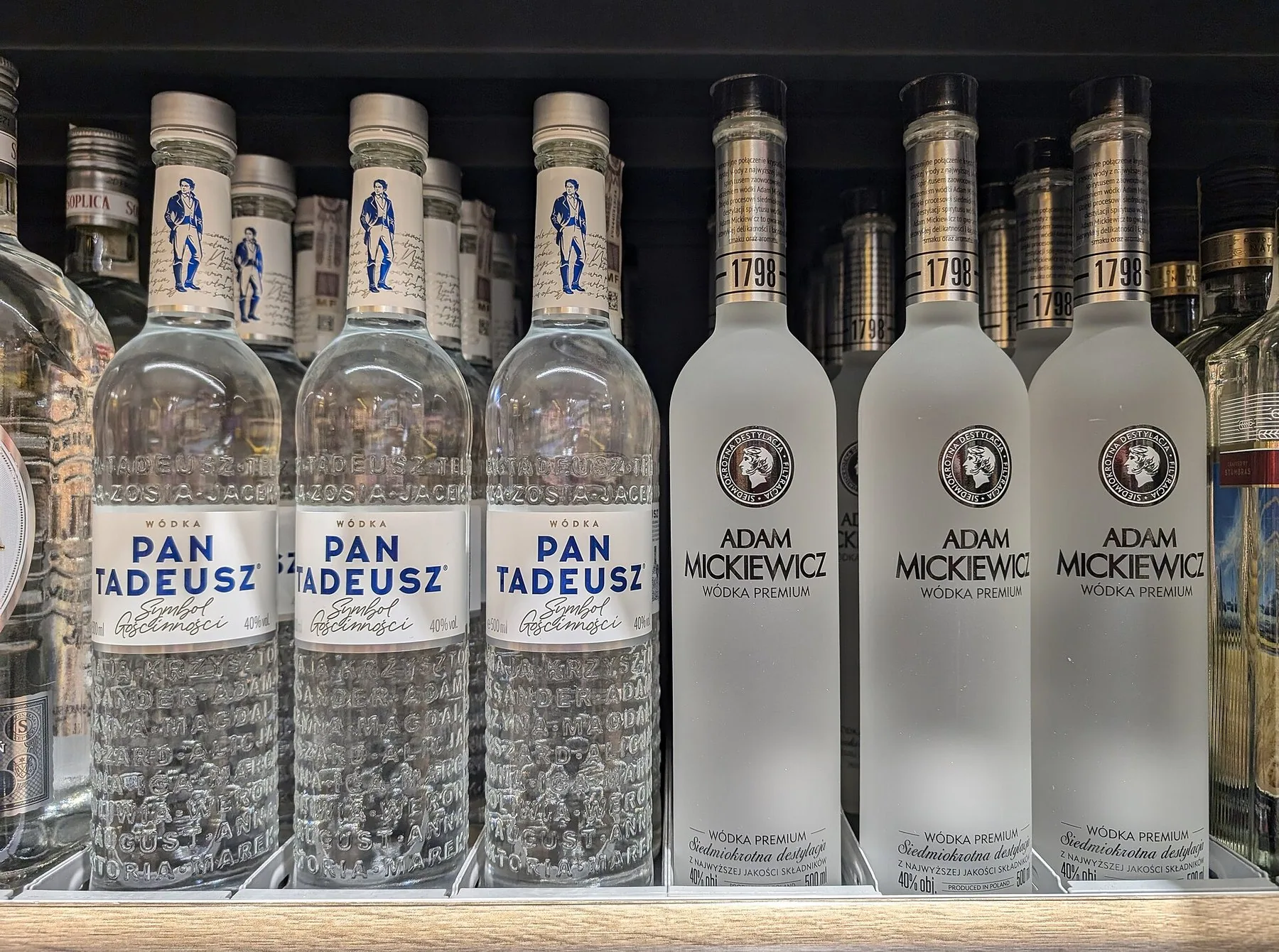 Flasker med polsk vodka av merkene Pan Tadeusz og Adam Mickiewicz i en hylle i en Biedronka-butikk