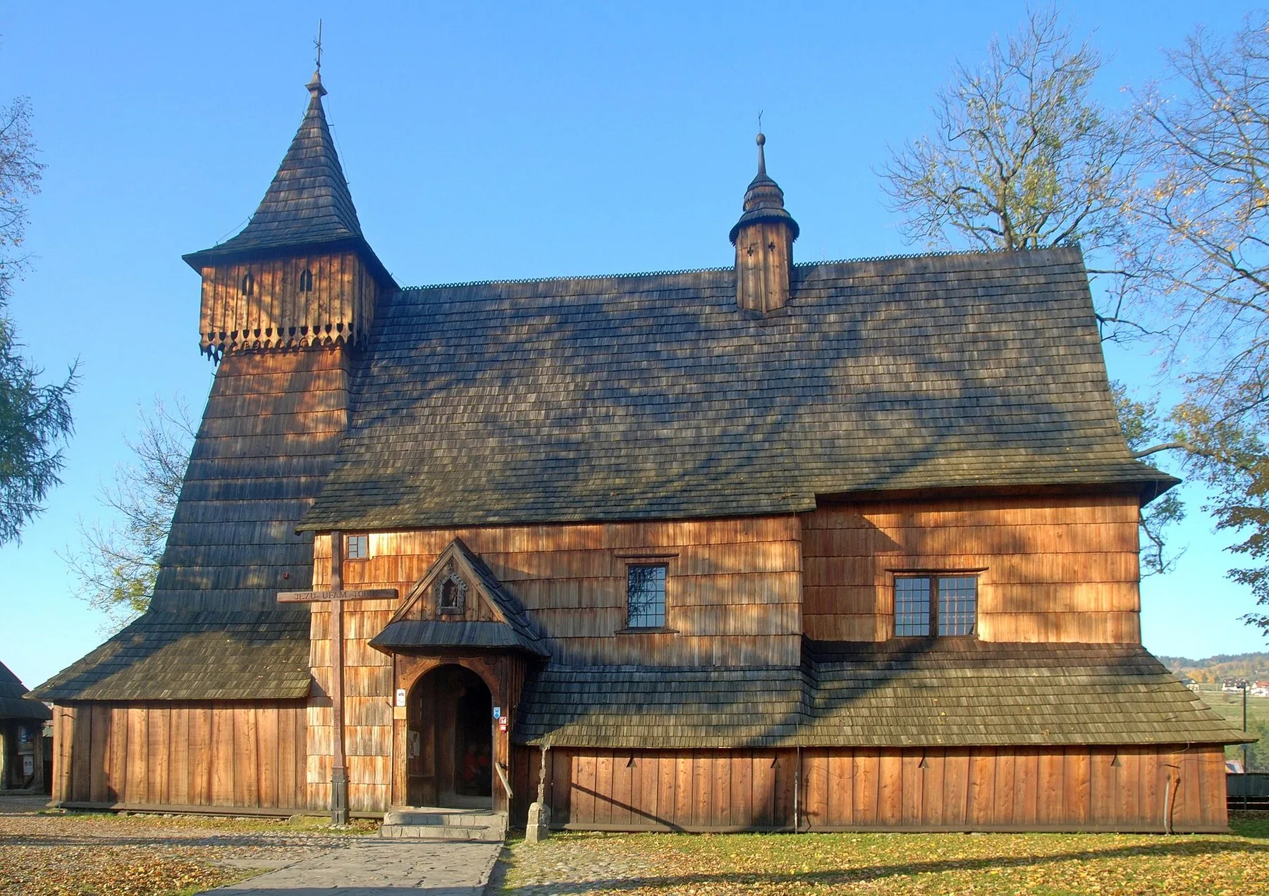 Trekirken St. Mikael i Dębno Podhalańskie med spontekket tak og klokketårn, en av Polens trekirker på UNESCOs verdensarvliste