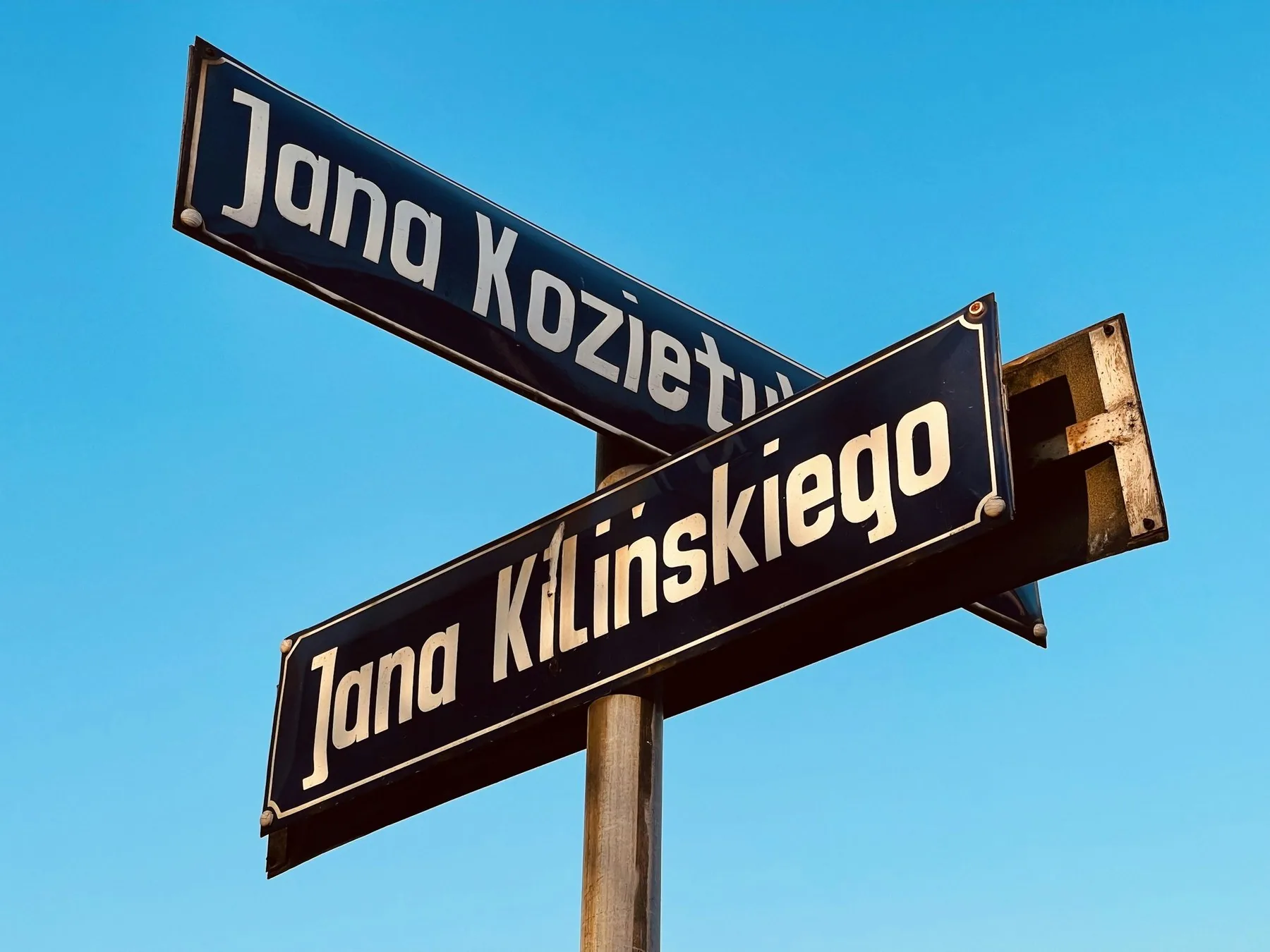 Polske gadeskilte med navnene Jana Kilińskiego og Jana Kozietulskiego mod blå himmel