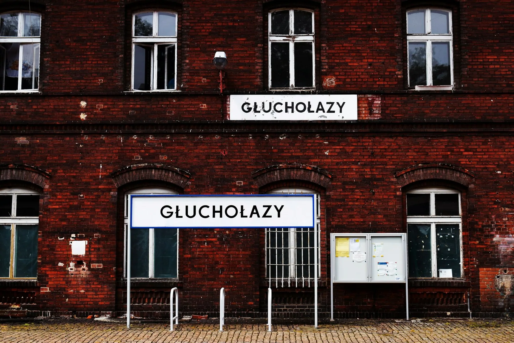 Stationsskylten Głuchołazy på en järnvägsstation i rött tegel